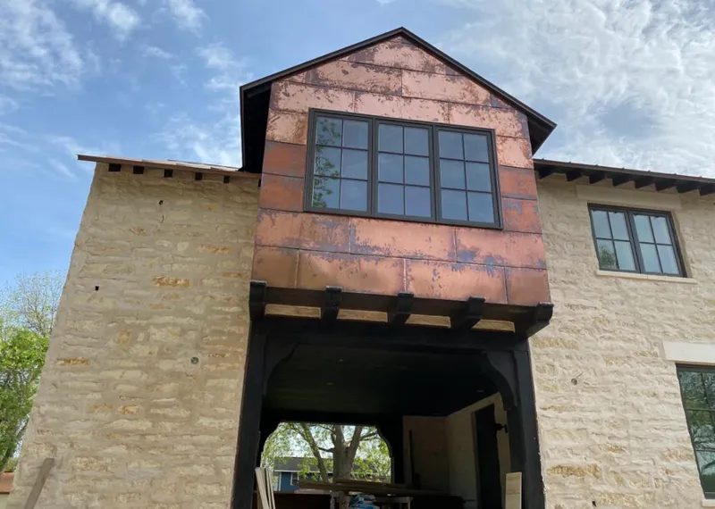 Copper metal panel facade on a stone building for Skylight Installation in Glenmont